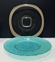 Front view of both platters; green bubble platter in foreground, clear square platter behind