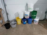 Group shot of all buckets and pails against garage door