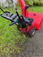 Full view of Ariens red snowblower showing controls, auger housing, tires
