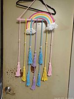 Full wall hanging with rainbow arch, braided cords and tassels on door
