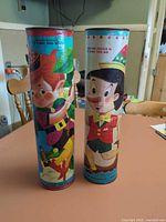 Two cylindrical puzzle tubes showing character graphics