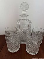 Front view of crystal decanter with stopper and four tumblers