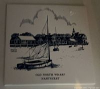 Front view of ceramic wall tile showing Old North Wharf Nantucket illustration
