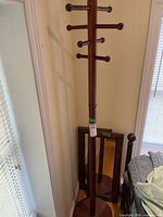 Full view of wooden coat rack with mirrors behind