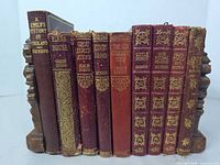 Spine view of all nine Dickens volumes showing titles, bindings, gilt decoration
