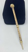 Full view of pencil on black stand showing overall form and engravings