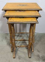 Three nested wooden tables showing size gradation and painted tops