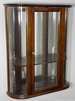 Front view of wood and glass Bombay Company wall curio cabinet