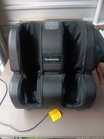 Front view of Brookstone foot and leg massager showing dual sleeves and brand label