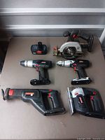Top-down view of the four power tools and battery
