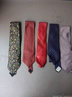 All five ties laid flat showing patterns and colors