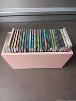 CDs stored upright in pink wooden box