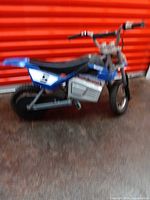 Left side profile of Razor MX350 showing frame, seat, rear wheel, battery box, and handlebar