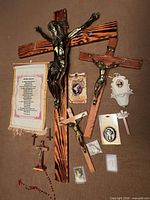 Overview of crucifixes, holy water font, prayer scroll, rosary and devotional items
