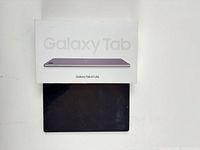 Front of Samsung Galaxy Tab A7 Lite tablet below its retail box
