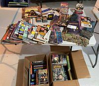 Overview of magazines, accessories, throw, two boxes of books under table