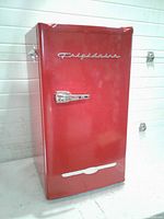 Front view of red Frigidaire mini fridge showing logo and chrome handle