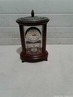 Front view of Bombay mahogany mantel anniversary clock showing dial and pendulum