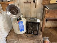 Propane infrared heater on cylinder next to electric space heater