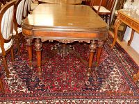 Full view of the antique dark wood carved rectangular table showing top and legs detail.