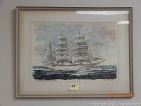 Framed watercolor of a sailing ship on the sea, signed Paul N. Norton, with grey metal frame and matting.