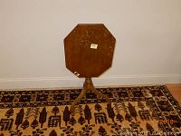 Side view of the small drop leaf table folded down, showing the three-legged pedestal base.