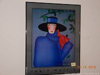 Framed poster depicting stylized portrait of woman in blue coat, black hat, red glove against green foliage background