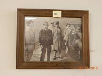 Framed black and white photo print of Humphrey Bogart in a scene from Casablanca, showing multiple figures in 1940s attire beside a vehicle.