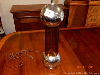 Photo of Mid Century Modern lamp with chrome spheres and amber plexiglass column on wood table