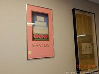 Framed Man Ray poster on a wall showing whole frame and some adjacent art