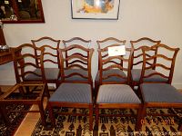 Eight wooden dining chairs arranged in two rows. One chair missing the seat cushion clearly visible.