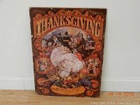 Full front view of vintage Thanksgiving poster mounted on board showing turkey, pilgrims, and harvest imagery.