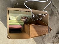 Top view showing Holy Bible, three smaller books, accordion file folder in box