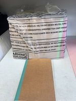 Factory-sealed plastic-wrapped bundle of notebooks beside one loose example