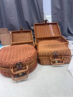 Four of the wicker baskets, round and rectangular, lids open and closed