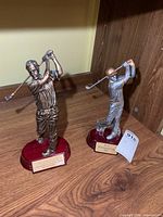 Both golf trophies on shelf showing overall appearance and relative size