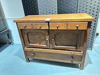 Front view of oak sideboard showing drawers, doors, hardware