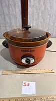 Full view of Rival Crock-Pot with lid, ruler for scale