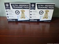 Two unopened AKC ultra-absorbent training pad boxes front view