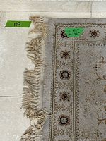 Fringed edge, pile texture and stain wear visible