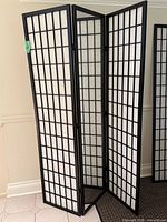 Full view of folded shoji screen showing three black-framed panels with white grid paper