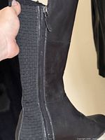 Side view showing leather upper, woven elastic panel and zipper