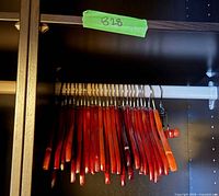 rack of reddish wooden hangers on white rod