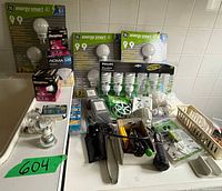 Overall lot showing sealed GE, Philips and NOMA bulb packages, loose bulbs, lamp, dimmers, tools