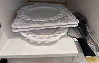 stacked pierced-rim ceramic plates with utensils to side