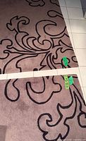 Full view of one rug showing overall color and scroll pattern