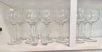 Group of wine glasses and shot glasses on shelf