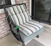Full view of one patio chair with striped cushions