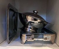 Chafing dish frame, glass insert, lid, and pedestal bowl stacked together