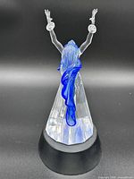 Rear view of crystal dancer showing blue cape and faceted skirt on black base
